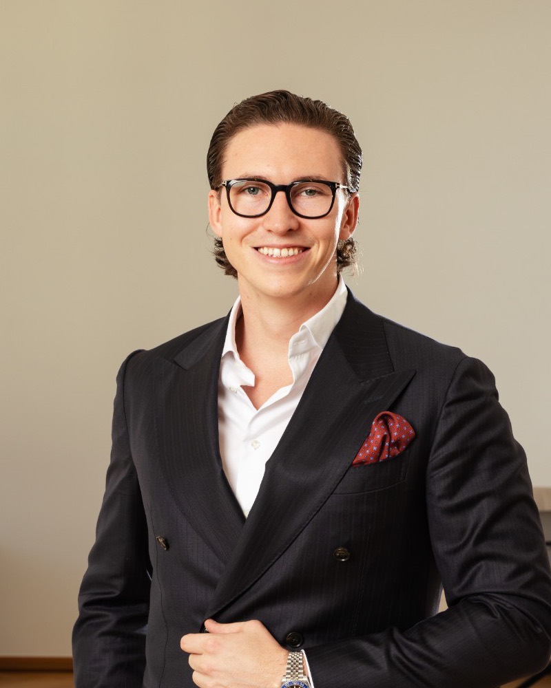 Porträt von Jürgen Nussbaumer mit schwarzer Brille und dunklem Zweireiher