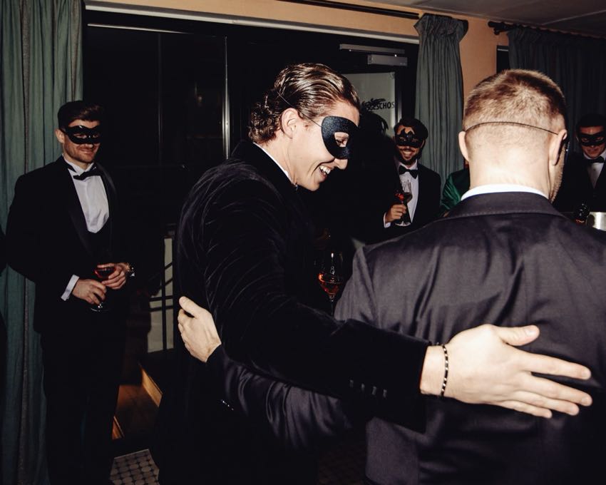 A warm embrace between two guests in dinner jackets at a NIC evening