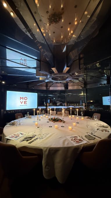 Festively laid round table in a dark restaurant with a ceiling of lights