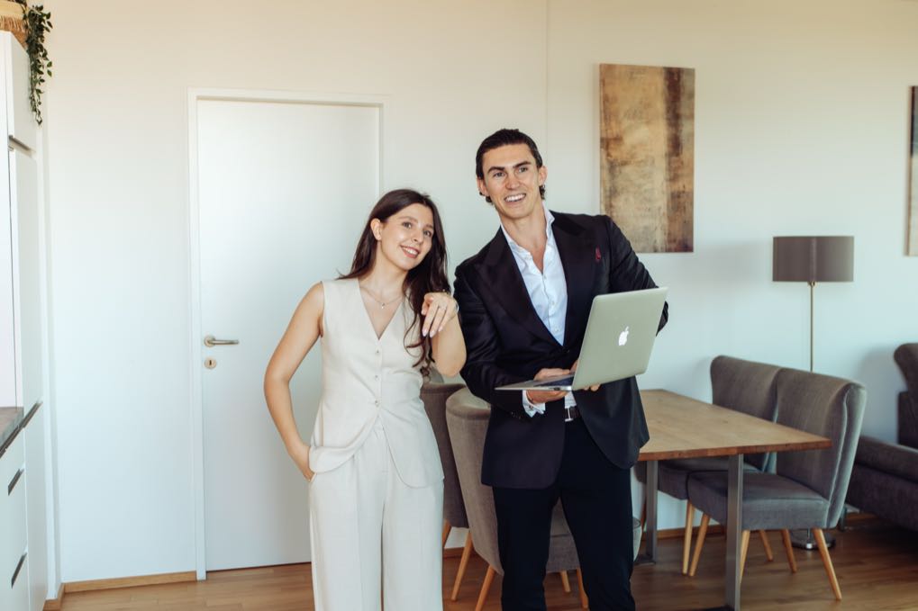 Jürgen Nussbaumer with a laptop and a woman in a bright apartment