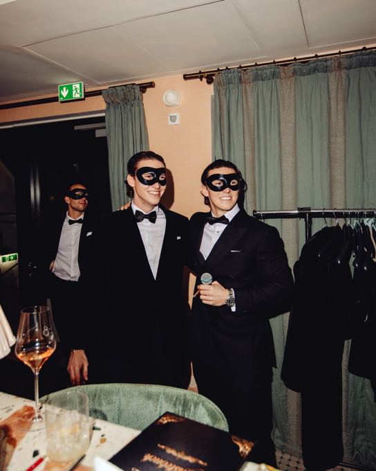 Guests in dinner jackets and eye masks at an evening event