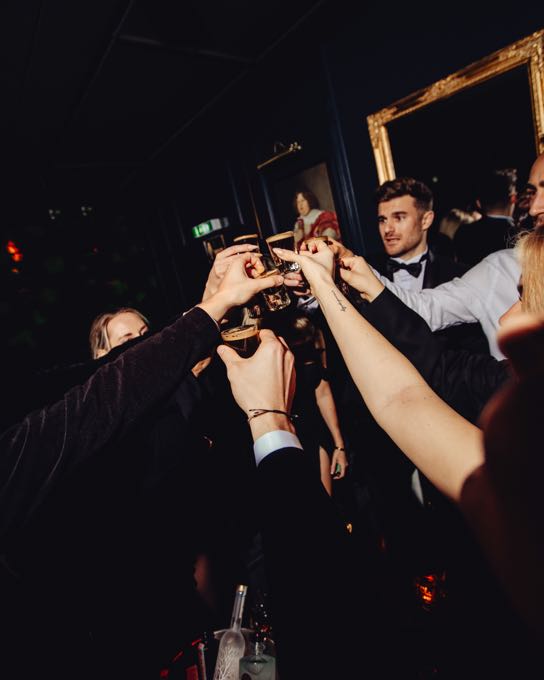 Guests raising their glasses at an evening event