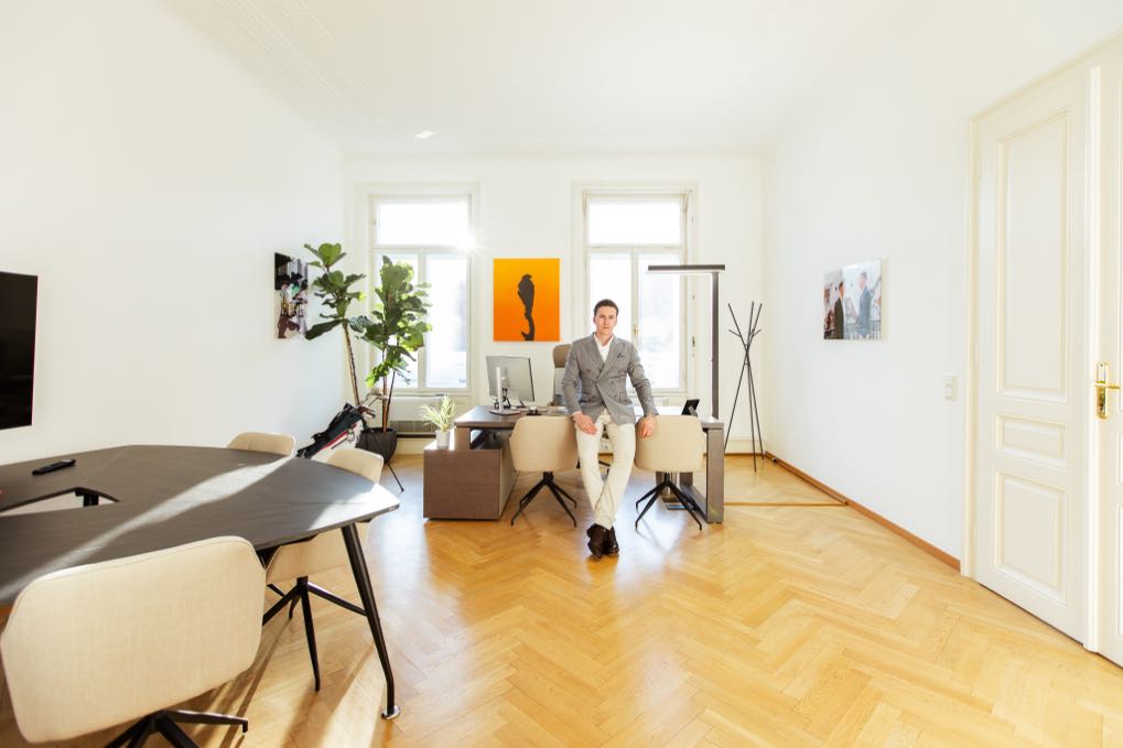 Man walking through a bright office with herringbone parquet