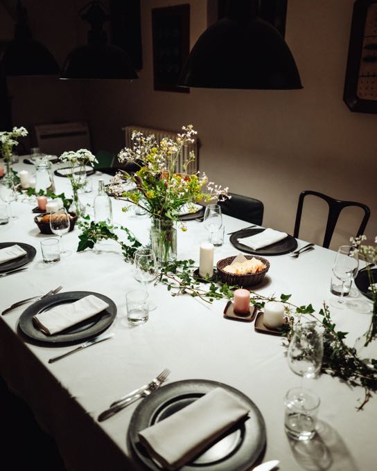 Long table laid with flowers in a dark room