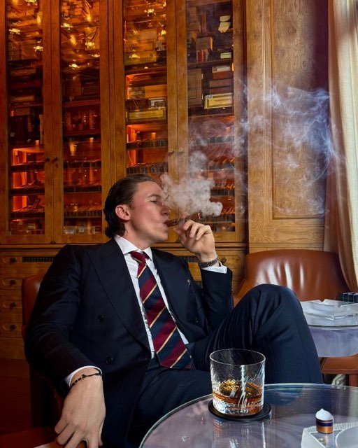 Guest in a suit with a cigar and a glass of whisky in a wood-panelled bar