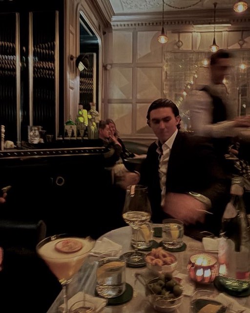 Guests at a laid table with cocktails in a dark bar