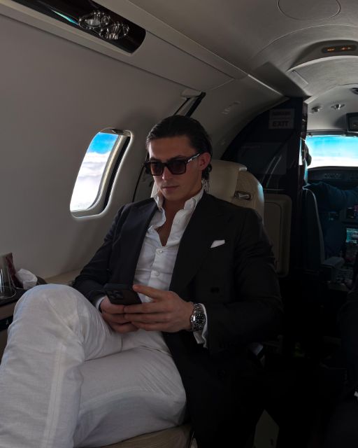 Man in a dark suit and sunglasses in the cabin of a private jet